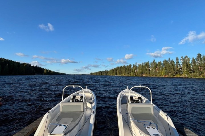 Two boats docked on a lake under a clear blue sky.