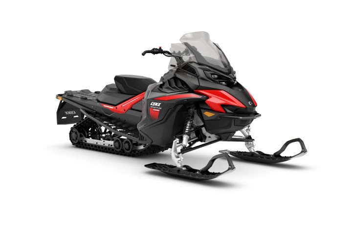 Black and red snowmobile with windshield and skis on front.
